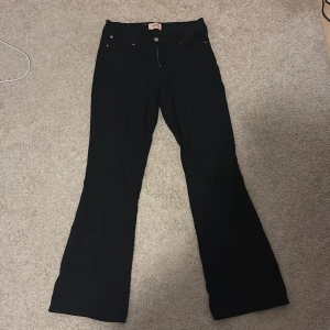 Svarta bootcut byxor - Snygga svarta byxor med bootcut-modell och klassisk femficksdesign. Byxorna har vida ben nertill och en stilren look som passar till många olika outfits. Perfekta för dig som gillar en tidlös och trendig stil.