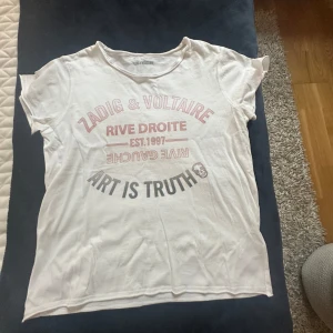 Vit t-shirt Zadig & Voltaire tryck - Vit t-shirt från Zadig & Voltaire med snyggt tryck framtill. För 14 år men skulle säga att den även kan passa storlek xs💕 i väldigt bra skick, endast använd två gånger!