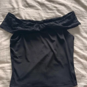 Svart offshoulder topp med spets - Snygg svart offshoulder topp med spets. Aldrig använd. Den passar både till vardag och fest. Passar storlek xs,s och M. Då den är ganska liten i storlek.
