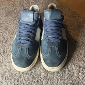 Valentino flycrew - Snygga Valentino flycrew sneakers i blå mocka med vita skinnpaneler och blå snörning. Yttersulan har coolt kamouflagemönster och små nitar baktill. Perfekta för dig som vill ha en exklusiv och sportig look med streetkänsla.