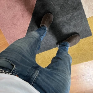 Mörkblå Replay jeans W29 L32 - Snygga blå jeans från Replay i klassisk denim med lätt slitning och smal passform. Modellen har fem fickor, svarta Replay-detaljer och midja med bälteshällor. Perfekta för dig som gillar en modern och stilren look. Jeansen har en defekt på vänstra fick och två på bakfickorna!
