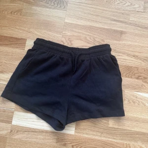 Svarta shorts från 157 XS - Svarta mjuka shorts från 157 i storlek XS. De har elastisk midja med snörning och är tillverkade i bomull, vilket gör dem riktigt sköna och perfekta för chill dagar eller träning. Klassisk och enkel design utan mönster eller extra detaljer.