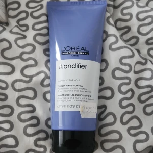 L'Oréal Blondifier Conditioner 200ml - Lila tub med L'Oréal Professionnel Blondifier Conditioner, 200 ml. Speciellt framtagen för blont eller slingat hår, innehåller açaí-polyfenoler för att ge glans och vård. Perfekt för dig som vill boosta lystern i ditt blonda hår.