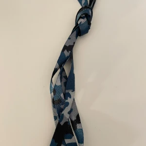 Nya oanvända skosnören  - Nya oanvända skosnören i blått militärmönster. Frakt på 22kr tillkommer. Betalning sker via Swish.