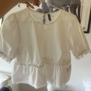 Vit volangblus från HM - Vit blus från HM med volangdetaljer och korta puffärmar i storlek 38! 