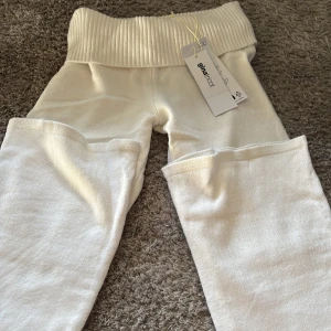 Vita stickade leggings Gina Tricot - Supermjuka vita stickade leggings från Gina Tricot med bred ribbad midja. Perfekta för en chill och avslappnad look. Materialet är stickat och känns riktigt skönt mot huden.
