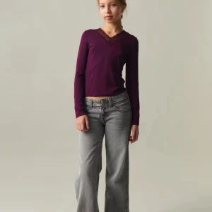 Vinröd långärmad topp med spets - Snygg lila långärmad topp med v-ringning och spetsdetalj vid halsen. Modellen är figurnära och passar perfekt till jeans eller kjol. Mjuk och skön bomullskänsla, enkel att styla för olika looks.