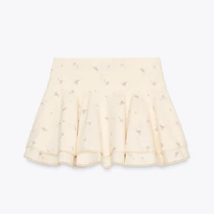 Supersöt ljusgul volangkjol - Supersöt ljusgul kortkjol med små blommor i rosa och volangkant. 