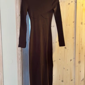 Brun långärmad klänning NA-KD - Snygg brun långklänning från NA-KD i ribbat material. Klänningen har lång ärm, figurnära passform och en öppen rygg som ger en cool touch. Perfekt för dig som gillar stilrena och trendiga plagg med det lilla extra. Använd 2 gånger. Den är ifrån Ida Carlssons kollektion med NAKD och är inköpt för 699kr, har inte fått så mycket användning för den därav att jag säljer den. Köparen står för frakten. Jag brukar ha S i storlek och är 157 cm så den är stor i storlek skulle jag säga.