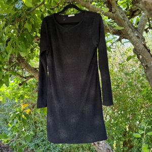 Svart glittrig klänning Ida Sjöstedt XL - Svart kortklänning från Ida Sjöstedt i storlek XL. Men den är liten i storlek. Mer en M/L. Klänningen har lång ärm och är täckt av små glittriga prickar som ger en snygg shimmer-effekt. Materialet är en mix av nylon, metallisk tråd, viskos och spandex för en stretchig och bekväm passform. Perfekt för dig som gillar att sticka ut. Mycket fint skick, jag hittar inga synliga anmärkningar eller defekter. 