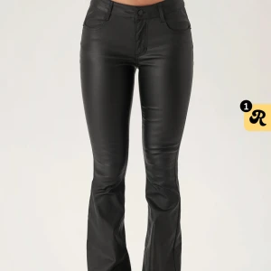 Svarta skinn byxor från Nelly  - Snygga svarta byxor i skinnimitation med bootcut passform och slits nertill på benen. 