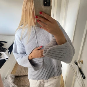 Ljusblå stickad tröja  - Ljusgrå stickad tröja med slitar vid ärmarna och vid höften. Tröjan är tjock och mjuk. Säljer pga knappt använt men den är verkligen så snygg💞