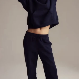 MÖRKBLÅ MJUKISBYXOR - Snygga svarta mjukisbyxor med dragsko i midjan och avslappnad passform. Perfekta för chill dagar eller när du vill vara bekväm men ändå se stilren ut. Tillverkade i mjukt material som känns skönt mot huden.