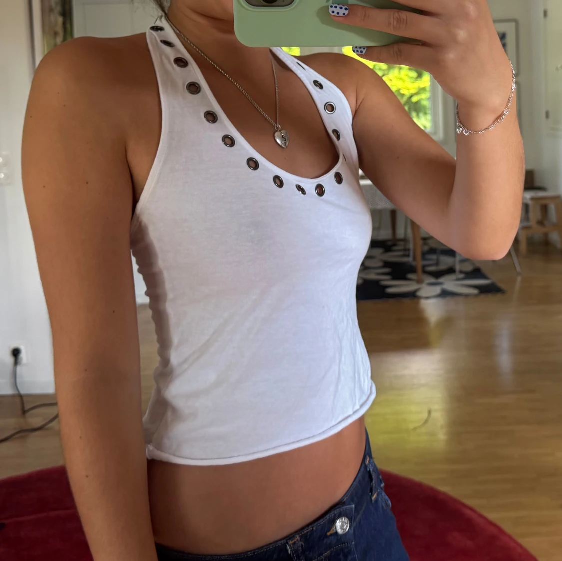 Vit croppad linnetopp med metalldetaljer