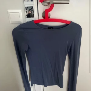 Mörkgrå långärmad topp Gina Tricot - En stilren mörkgrå långärmad topp från Gina Tricot i storlek XXS. Toppen har en enkel, tight passform och är tillverkad i ett mjukt och stretchigt material som sitter snyggt på kroppen. Perfekt att matcha med jeans eller kjol för en clean look.