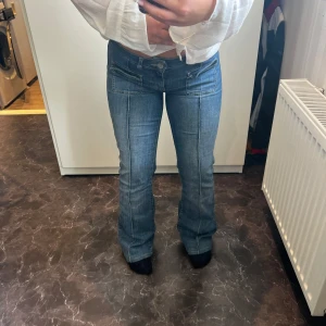 Blå bootcut jeans med fickdetaljer - Säljer ett par blå jeans med bootcut och låg midja från Nelly, Stretchigt material🤩