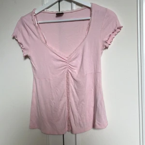 Ljusrosa topp med spets - Supersöt ljusrosa topp från Gina Tricot med v-ringning. Använd 1 gång!