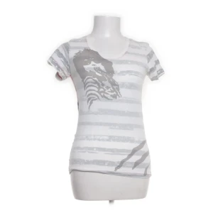 Snygg topp  - från topshop x kate moss collab ! Modellen är figurnära med rund hals och korta ärmar. Perfekt för dig som gillar unika prints och streetstyle.