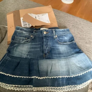 Jeanskjol med spetsdetaljer - Supersöt jeanskjol med volanger och spetsdetaljer! Använd en gång så som ny 💞 står ingen storlek men skulle säga S 🥰