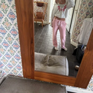 Vit hoodie med röd print och dragkedja - Säljer en vit hoodie med röd grafisk print framtill. Tröjan har dragkedja hela vägen, huva och är långärmad. Passformen är croppad och lite loose, perfekt för en chill look. Materialet känns som mjuk bomull eller polyester.