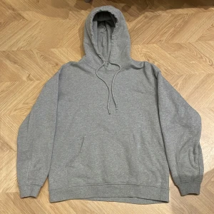 Grå hoodie från Vailent - Säljer en klassisk grå hoodie från Vailent i storlek S. Den har en boxig fit och är ett schysst basplagg. Har en liten fläck (se bild) men inget som märks.