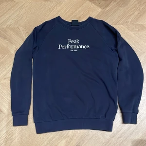 Mörkblå tröja från Peak Performance - Säljer en snygg stilren mörkblå tröja från Peak Performance med deras logga broderad på framsidan. 