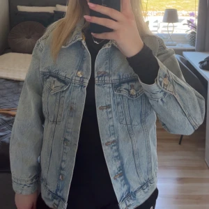 Ljusblå jeansjacka från Perfect Jeans - Säljer en klassisk ljusblå jeansjacka från Perfect Jeans Gina Tricot. Jackan har en normal passform med knappar framtill och två bröstfickor med lock. Perfekt för vår och sommar!