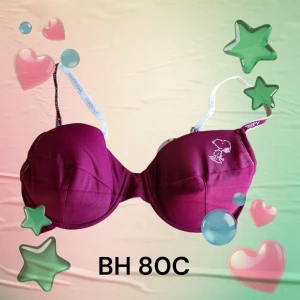 Snobben-bh 80C - Vinröd snobben-bh med broderad Snoopy-detalj på ena kupan och Snoopy tryck på axelbanden. Uttagbara inlägg. Helt oanvända med prislappen kvar. Kommer från konkurslager.