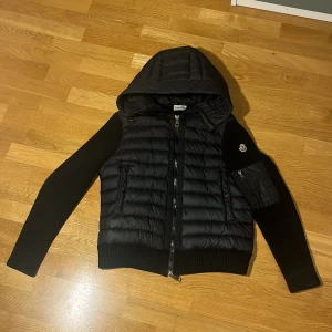 Svart pufferjacka från Moncler - Intressekoll på min moncler jacka! Tar även emot byten av andra moncler. Snygg svart pufferjacka från Moncler med huva och dragkedja. Jackan har långa ärmar och ribbade detaljer. Perfekt för kyligare dagar med sin stilrena design och praktiska fickor. Stl S. 