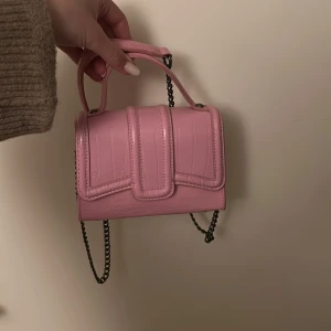 Rosa axelväska med kedja - Snygg rosa axelväska från zara med krokodilmönster och en kedja som axelrem.