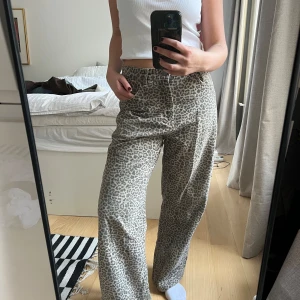 Leopardmönstrade byxor från Zara - Snygga leopardmönstrade byxor från Zara med en loose passform. Perfekta för att ge din outfit en trendig touch. Byxorna har en bekväm midwaist och är tillverkade i ett mjukt material.