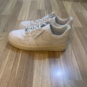 Beige Nike Air Force sneakers - Säljer ett par stilrena beige Nike Air Force sneakers. De har en klassisk design med snörning och rund tå. Perfekta för en avslappnad stil.