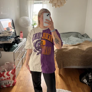 Tvåfärgad t-shirt med tryck - Unik t-shirt med en cool design i två färger, lila och beige/vit. Ena sidan är lila med ett orsnge tryck och den andra sidan är beige/vit med ett lila tryck. Perfekt för dig som vill sticka ut!