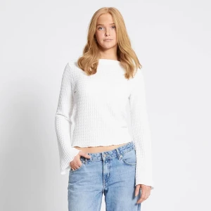 Vit ribbad tröja - Säljer en stilren vit ribbad tröja med långa ärmar och en croppad passform. Perfekt för en avslappnad look. 