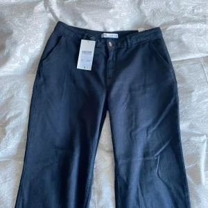 Svarta byxor från Zara - Snygga svarta byxor från Zara med en klassisk design. De har en rak passform och är tillverkade i ett bekvämt material. Perfekta för en stilren look.