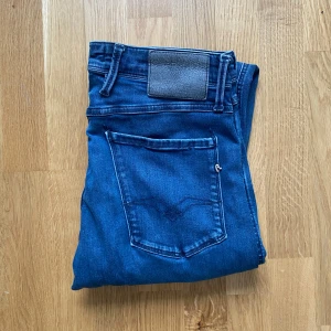 Replay anbass - Snygga blå jeans från Replay med klassisk femficksdesign och knappgylf. Perfekta för en avslappnad stil.