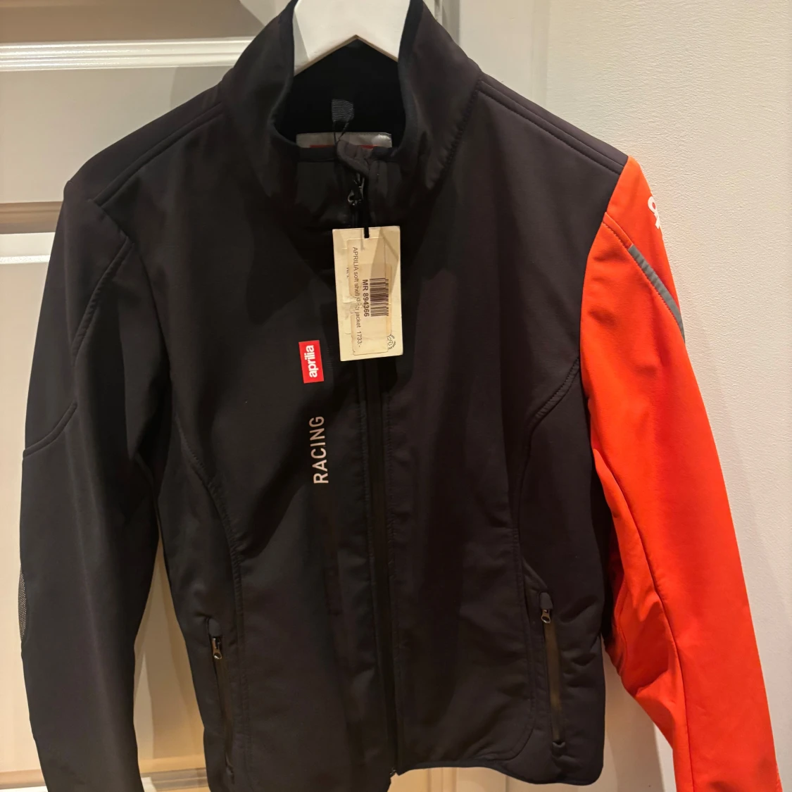 Svart och orange racingjacka från Aprilia - 1