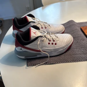Vita och röda Nike Air Jordans - Säljer ett par stilrena Nike Air Jordans i vitt och rött. Skorna har snörning och en rund tå, med den ikoniska Jumpman-loggan på plösen. Perfekta för dig som vill ha en sportig och trendig look.