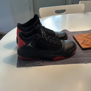 Svarta och röda Nike Air Jordans - Säljer ett par snygga svarta och röda Nike Air Jordans. Skorna har en klassisk design med snörning och rund tå. Perfekta för dig som älskar stil och komfort i ett.
