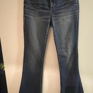Blå bootcut jeans från American Eagle - Snygga blå bootcut jeans från American Eagle med superstretch för extra komfort. Slitna i skrevet dock inget som syns. Botcut jeans.  Frågor eller fynd är de bara att skriva💕