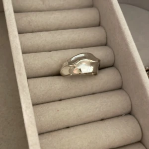 Silvrig ring med detaljerad form - Ringen ser ut att vara lite guppig vilket gör den super fin och unik? Om det ser ut som rost på någon av bilderna så är det inte det utan ringen reflekterar bara min hy🥹