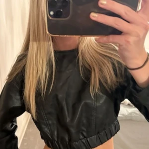 Svart croppad skinntopp - Snygg svart croppad skinntopp med långa ärmar och elastisk midja. Toppen har en dragkedja baktill 🖤