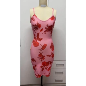 Rosa blommig klänning från NLY One - Snygg rosa klänning med röda blommor från NLY One. Den är ärmlös med smala axelband och har en tight passform som framhäver figuren. Perfekt för en somrig look!