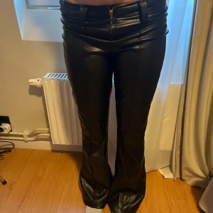 Svarta skinnbyxor - Snygga svarta skinnbyxor med låg midja och dragkedja fram. Byxorna har en bootcut-stil. Populära ifrån newyorker. Har lite defekter (skriv för att få se bild). Pris går att diskutera 