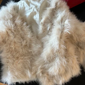 Beige pälsväst - Säljer en fluffig och stilren beige pälsväst. Perfekt för att hålla sig varm och trendig under kyligare dagar. Västen har en mjuk och lyxig känsla, vilket gör den till ett måste i garderoben.