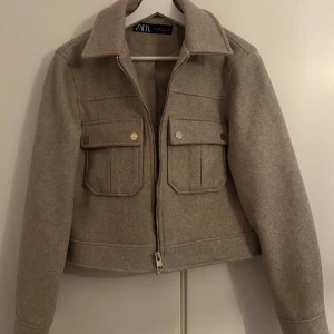 Beige jacka från Zara - Snygg beige jacka från Zara med dragkedja och två framfickor med knappar i guld. Super fin vårjacka! 🥰