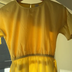 Gul blus från Lindex - Säljer en solig blus från Lindex för barn i storlek 134/140. Blusen har korta ärmar och en elastisk midja för en bekväm passform. Perfekt för varma dagar och har en enkel design med en knapp i nacken.Köpte den är 2 år sen ungefär för 250 och säljer den för 90kr🌟