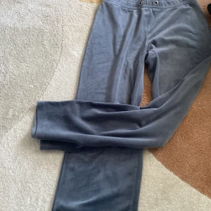 Grå mjukisbyxor från Gina Tricot - Säljer ett par grå mjukisbyxor från Gina Tricot. Byxorna har en bekväm passform med resår i midjan och metallöljetter för snörning. Perfekta för en avslappnad stil.