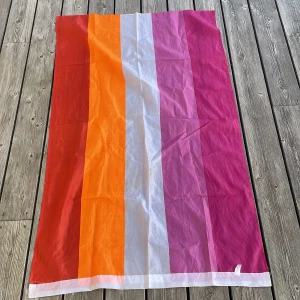 Flerfärgad lesbisk flagga från Happy Pride - Säljer en färgglad lesbisk flagga från Happy Pride med breda ränder i rött, orange, vitt och rosa.