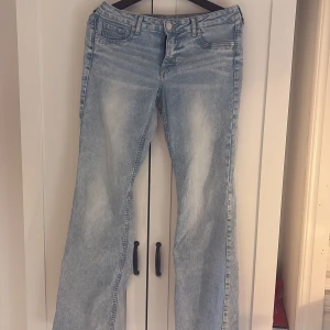 Ljusblå bootcut jeans från Hm - Säljer ett par ljusblå bootcut jeans från Hm med låg midja. Jeansen har klassisk femficksdesign och är tillverkade i denim. Perfekta för dig som gillar en retroinspirerad look.